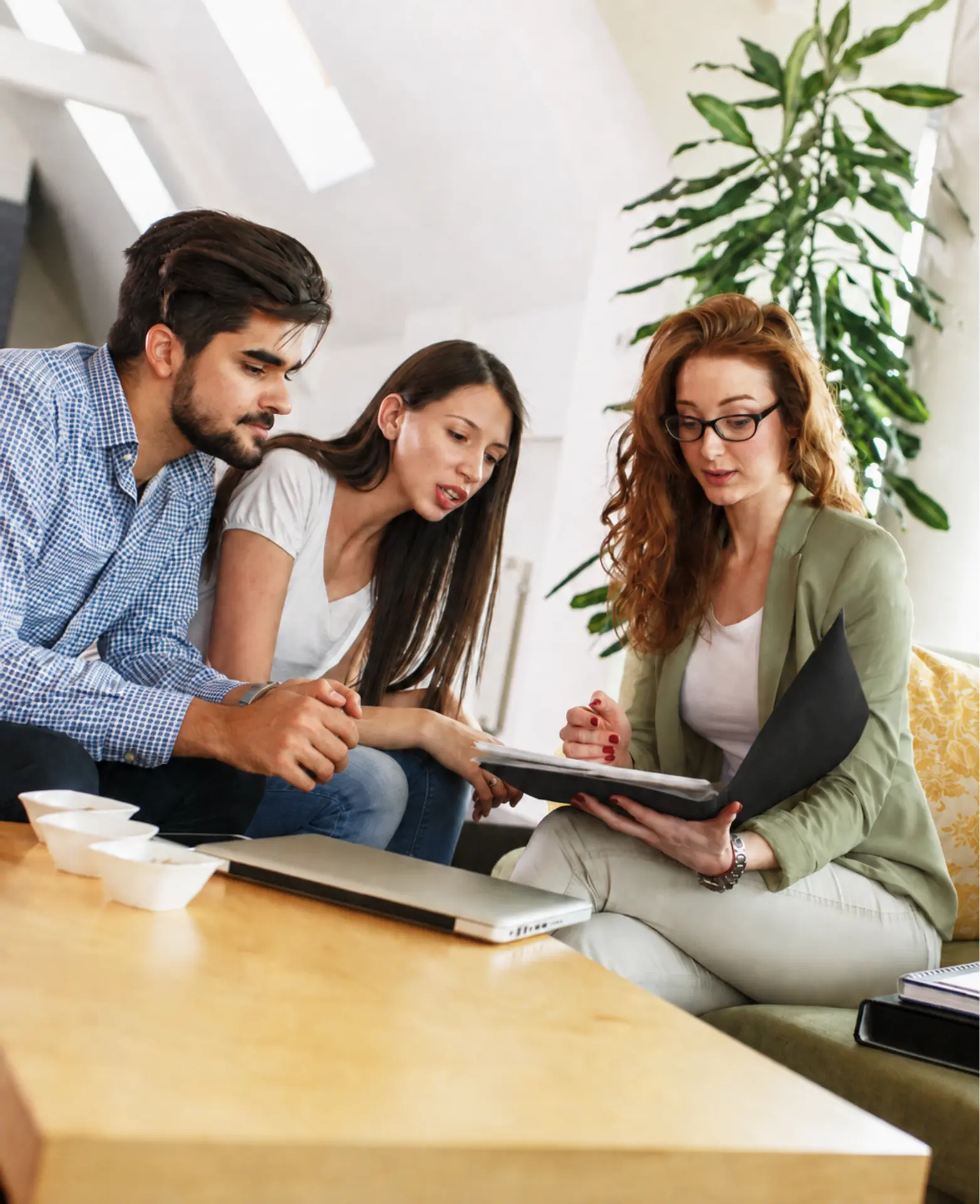 A couple reviewing property paperwork with a real estate professional at a table