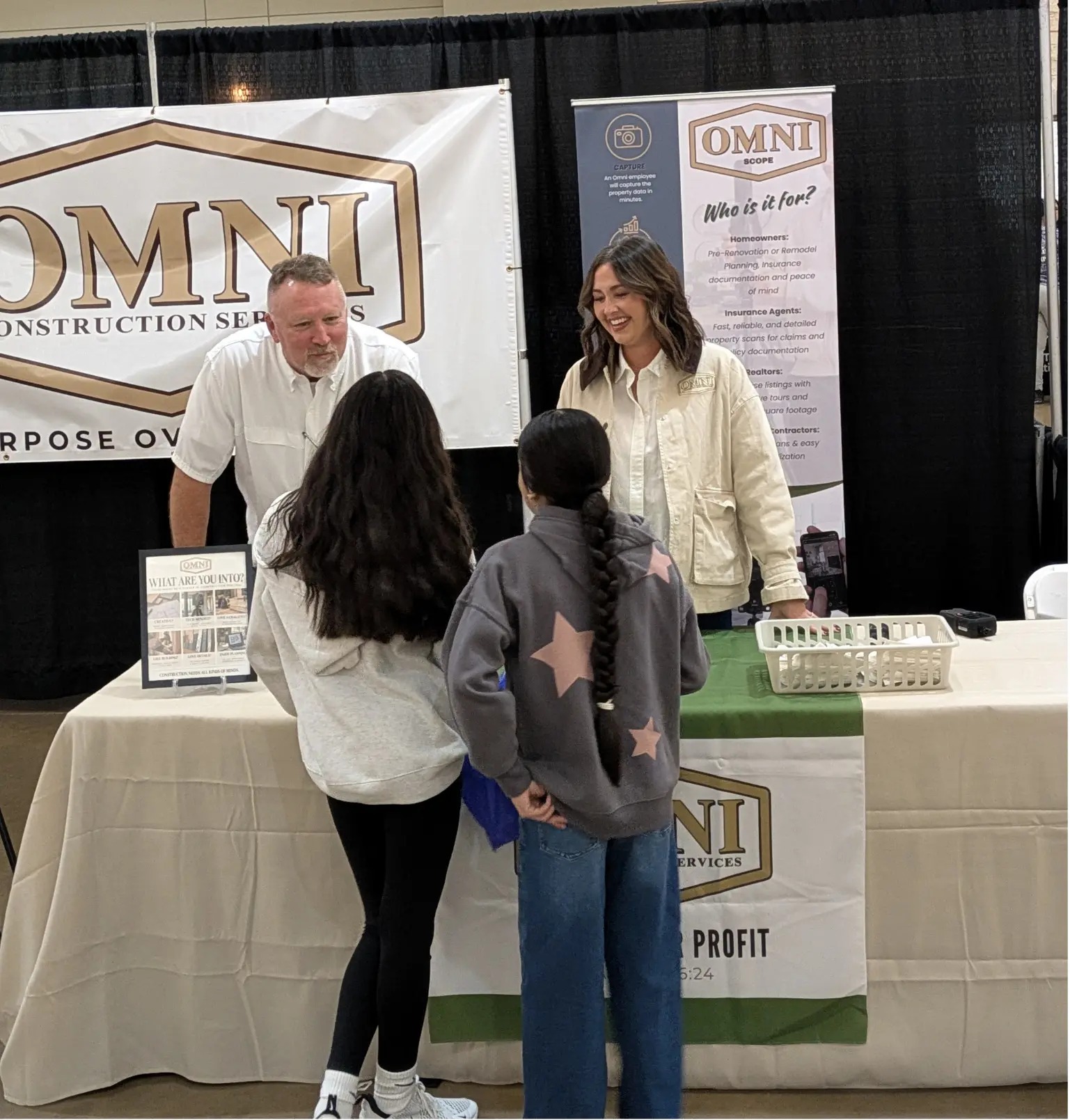 OMNI staff talking with visitors at a community booth