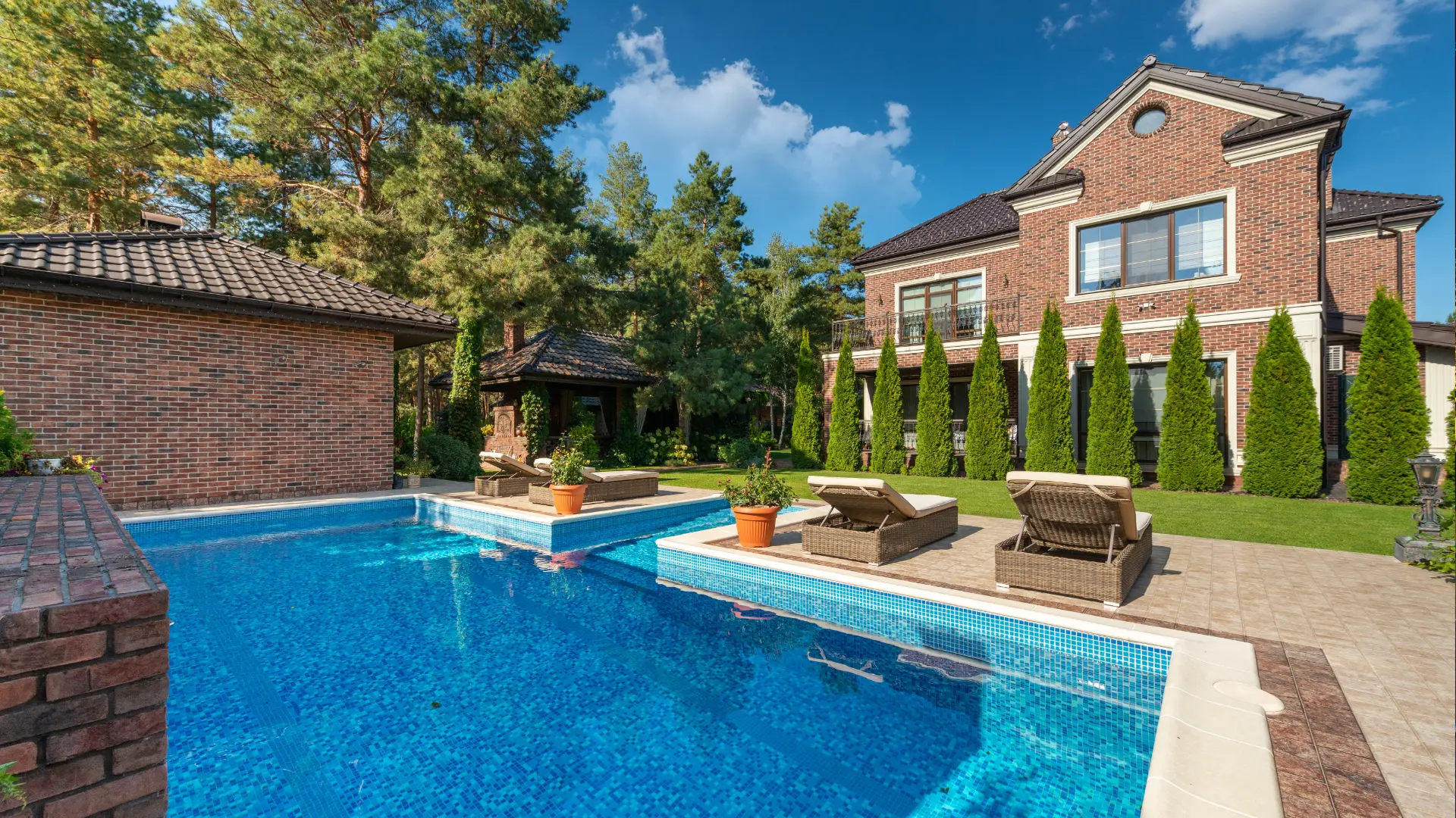 Custom pool house casita with a modern farmhouse exterior and covered entertaining area, built by OMNI Construction